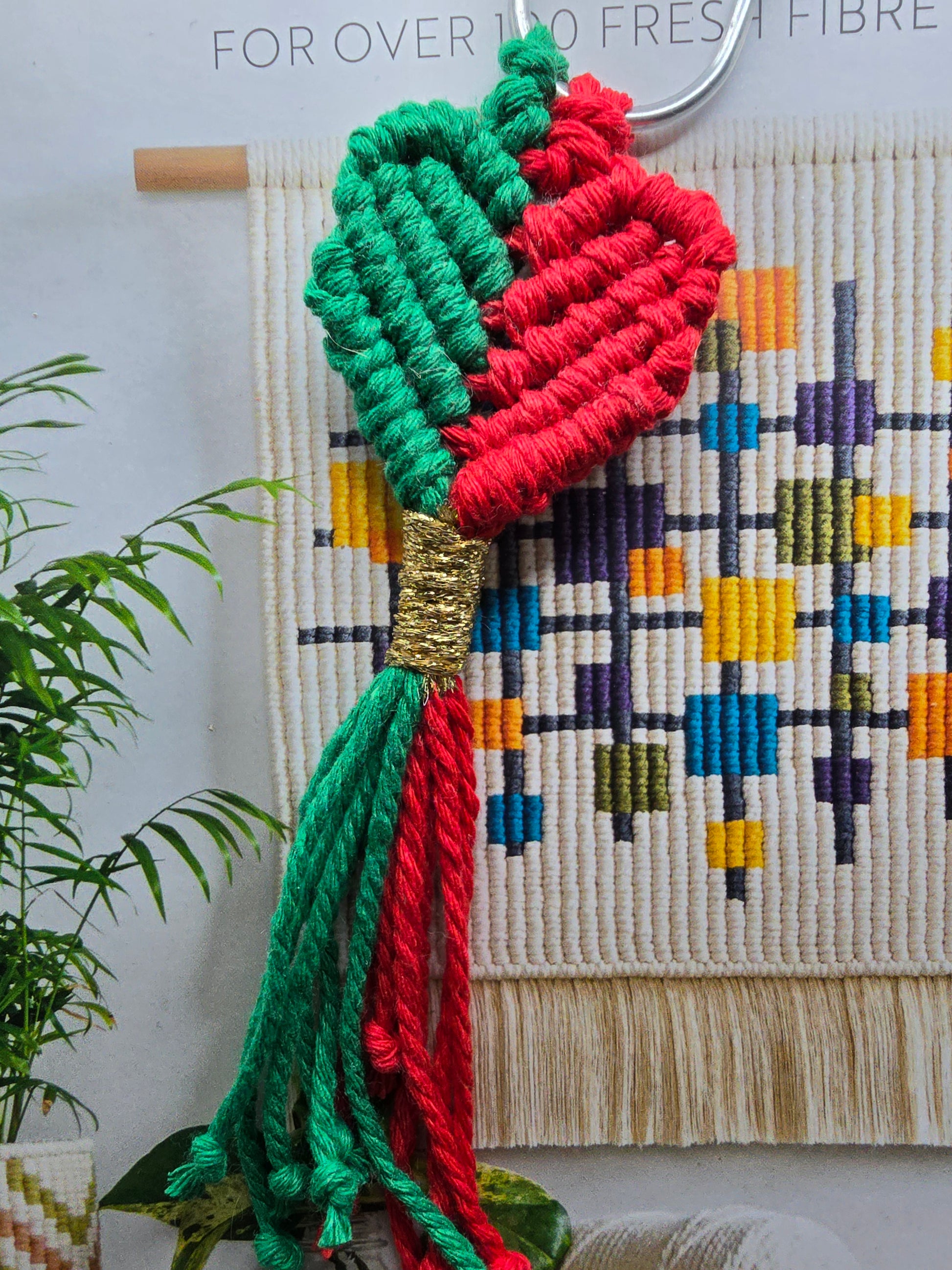 Handcrafted macrame bookmark in red, green, with a heart shape
