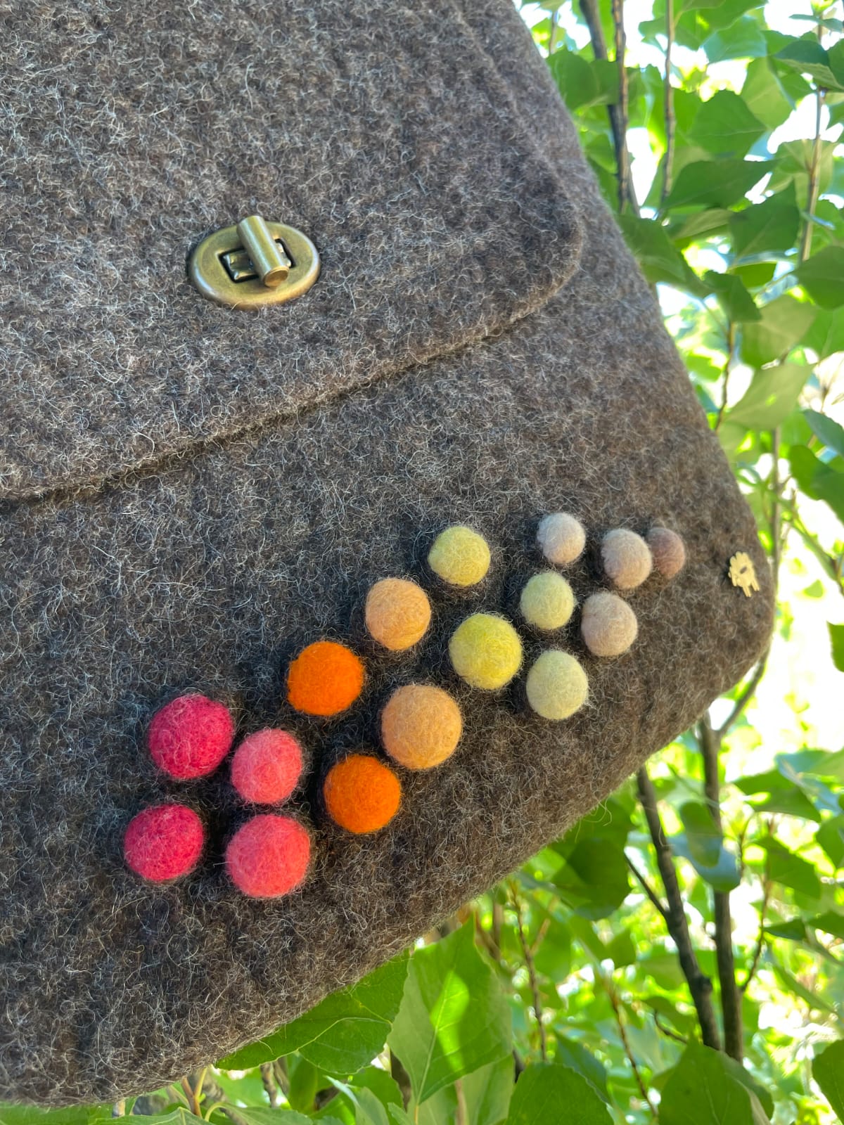 Close-up detail of felt handbag highlighting the natural Merino wool texture and artisanal finish.