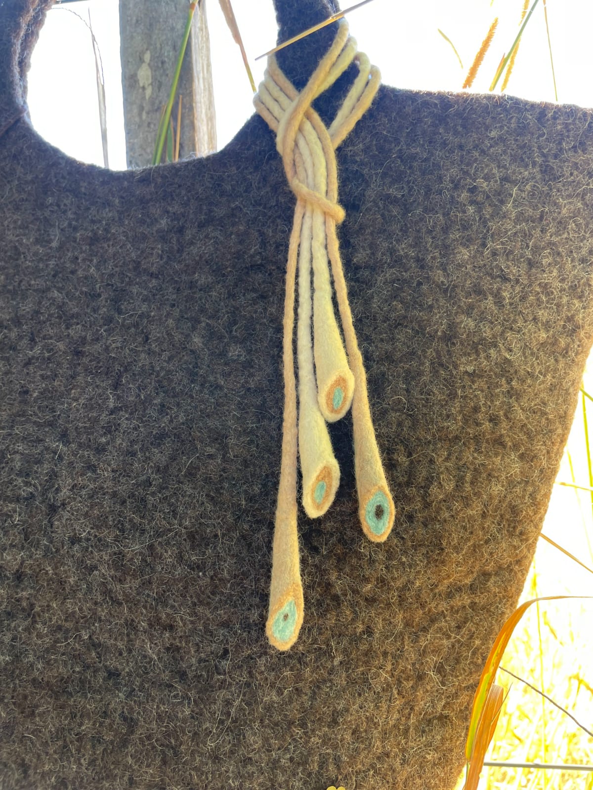 Close-up detail of felt handbag highlighting the natural Merino wool texture and artisanal finish.