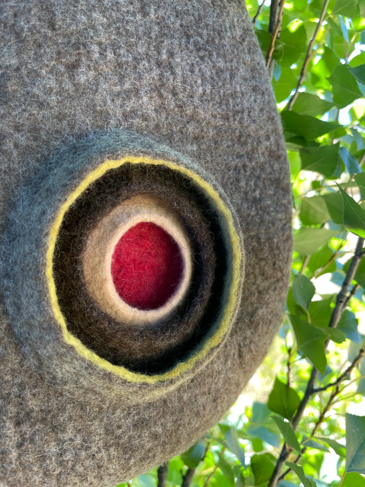 Close-up detail of felt handbag highlighting the natural Merino wool texture and artisanal finish.