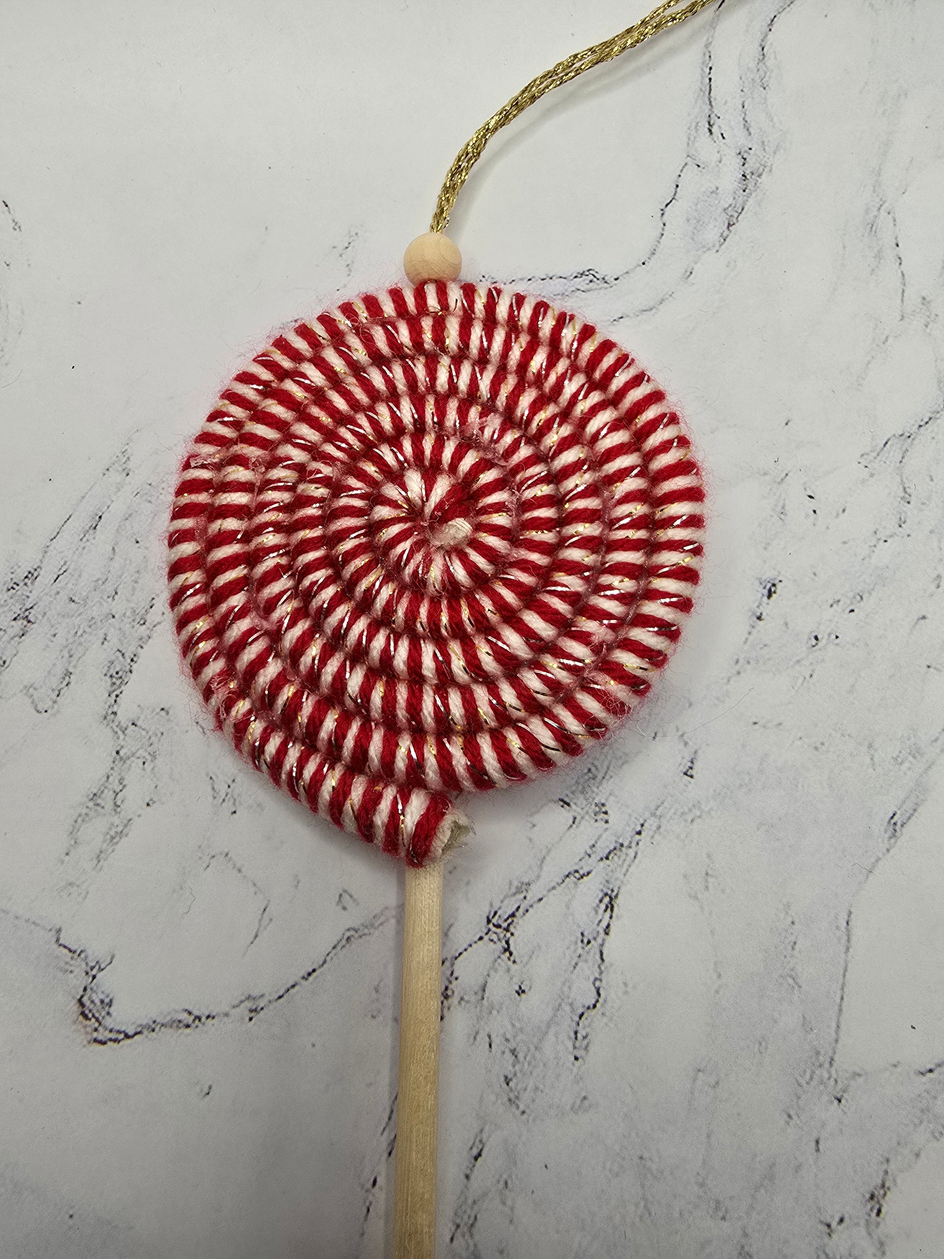 Macramé candy cane ornament styled as tabletop decoration – cozy handmade holiday décor.