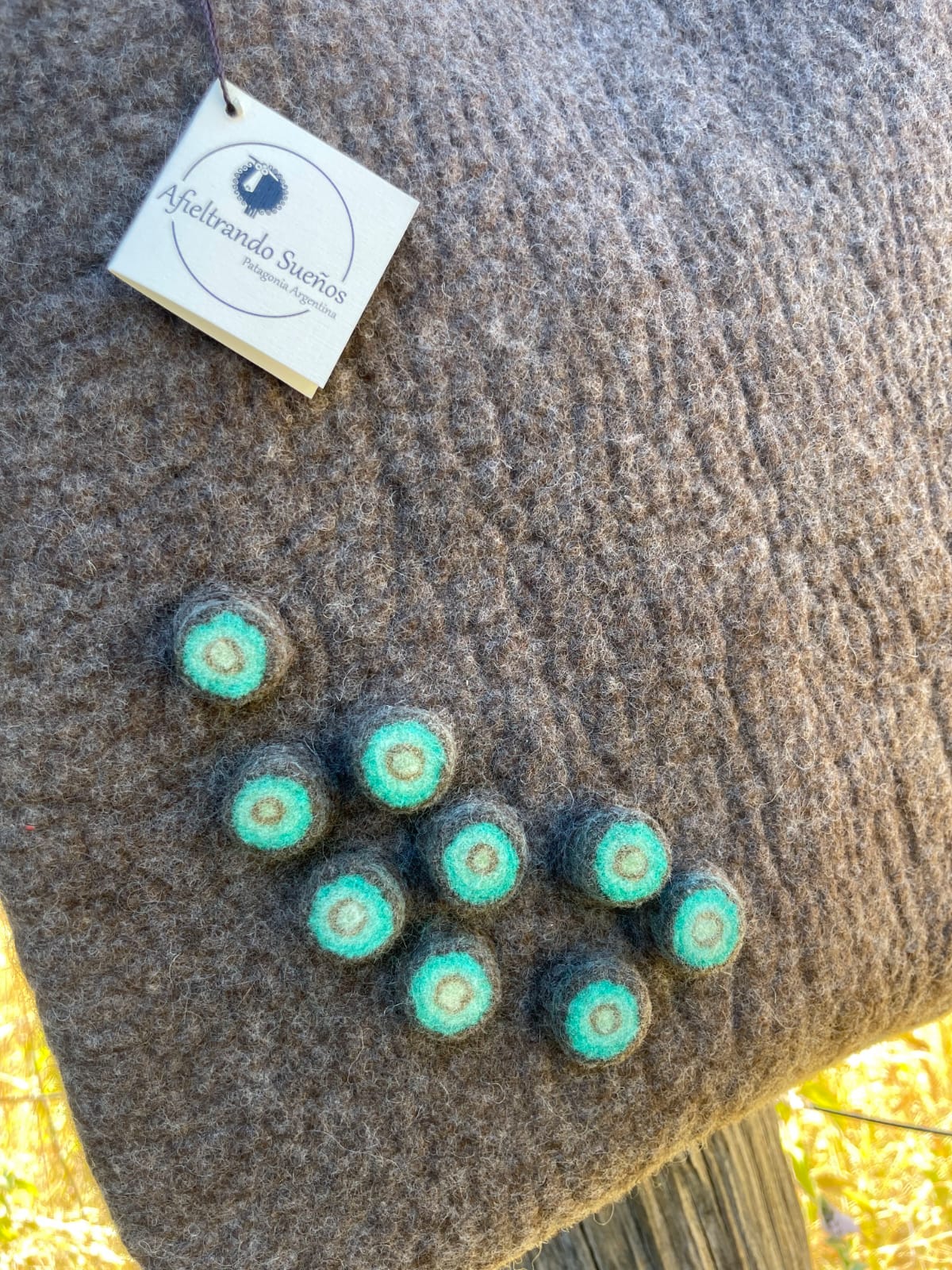 Close-up detail of felt handbag highlighting the natural Merino wool texture and artisanal finish.