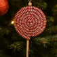 Close-up of handcrafted candy cane ornament made of cotton and wool, perfect for Christmas tree or gift tag.