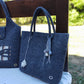 Side view of handmade Merino wool felt handbag showing soft texture and seamless craftsmanship.