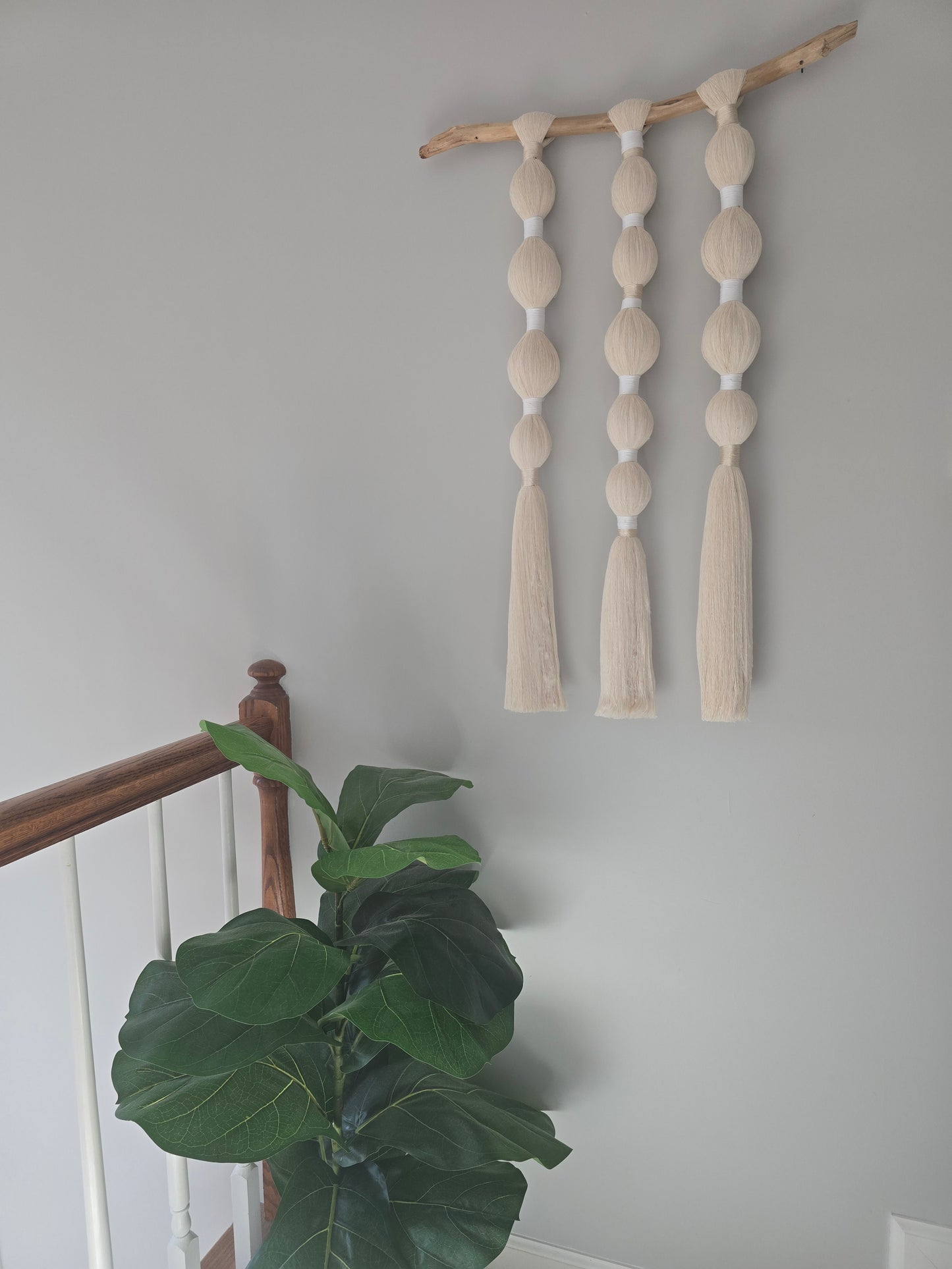 Close-up detail of knots and texture in a handmade macramé wall hanging made with recycled cotton