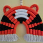 Close-up detail of handmade tiger rainbow wall hanging showing cotton cord texture and bright orange color.